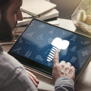 Person touching a digital screen displaying a glowing dental implant icon among other medical and dental symbols.