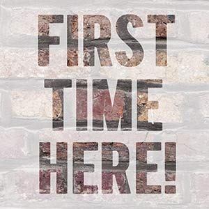 Text reading 'FIRST TIME HERE!' in large, bold letters over a faded brick wall background.