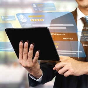 Person in suit holding a tablet with floating digital review and quality rating interface.