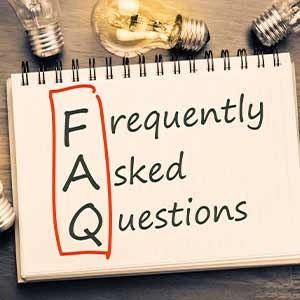 Spiral notebook page with 'FAQ' highlighted vertically and the words 'Frequently asked questions' written next to it, surrounded by light bulbs.