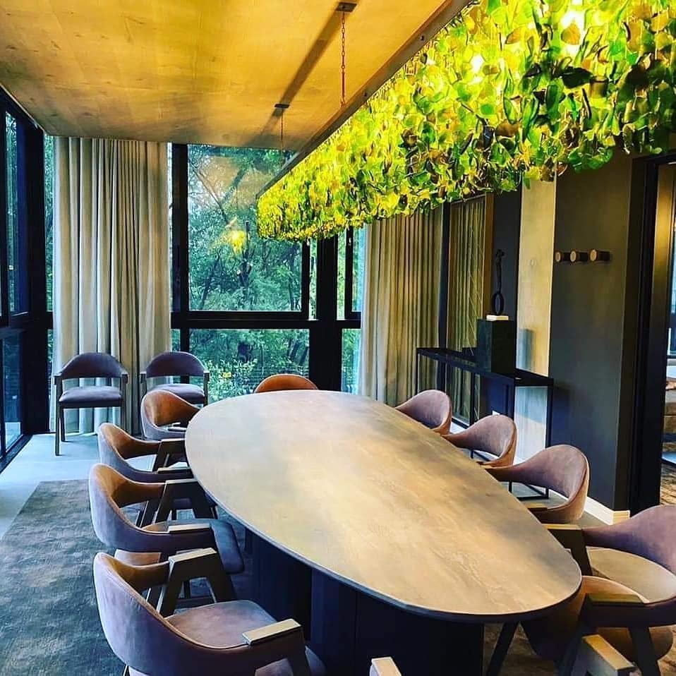 Green sea glass linear chandelier above a dining table, custom made for Balwin and Legaro