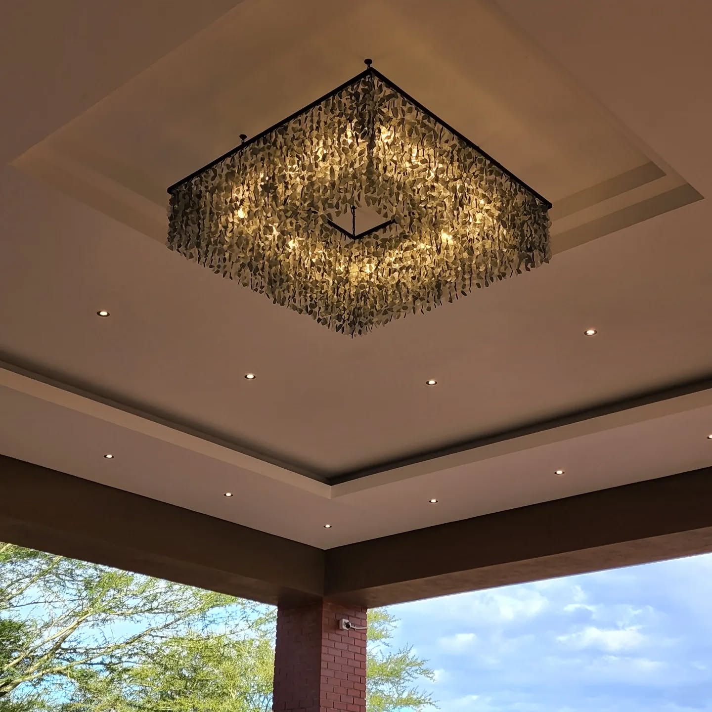 Half-moon white and blue sea glass chandelier in a double-volume interior