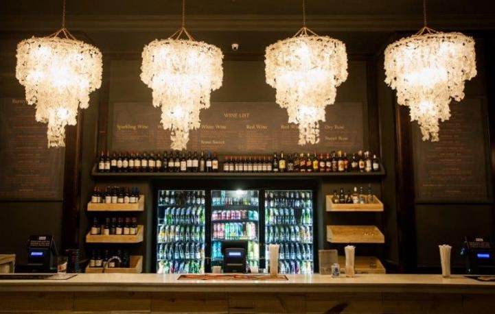 Multiple crystal chandeliers over a bar in a theatre