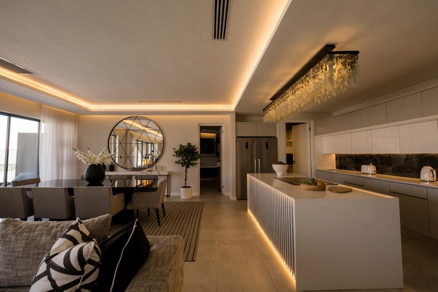 A white tiered chandelier over a dining room table