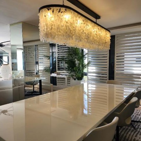 A waterfall type white chandelier in a double volume space