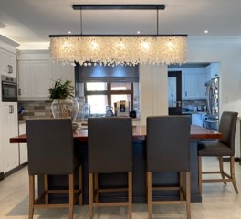 A white linear chandelier over a diming room table. 