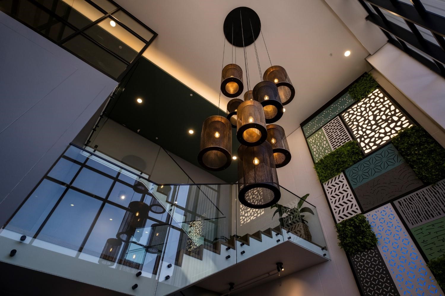 Multiple Brass, Black and Copper Light Fittings in a double volume atrium 