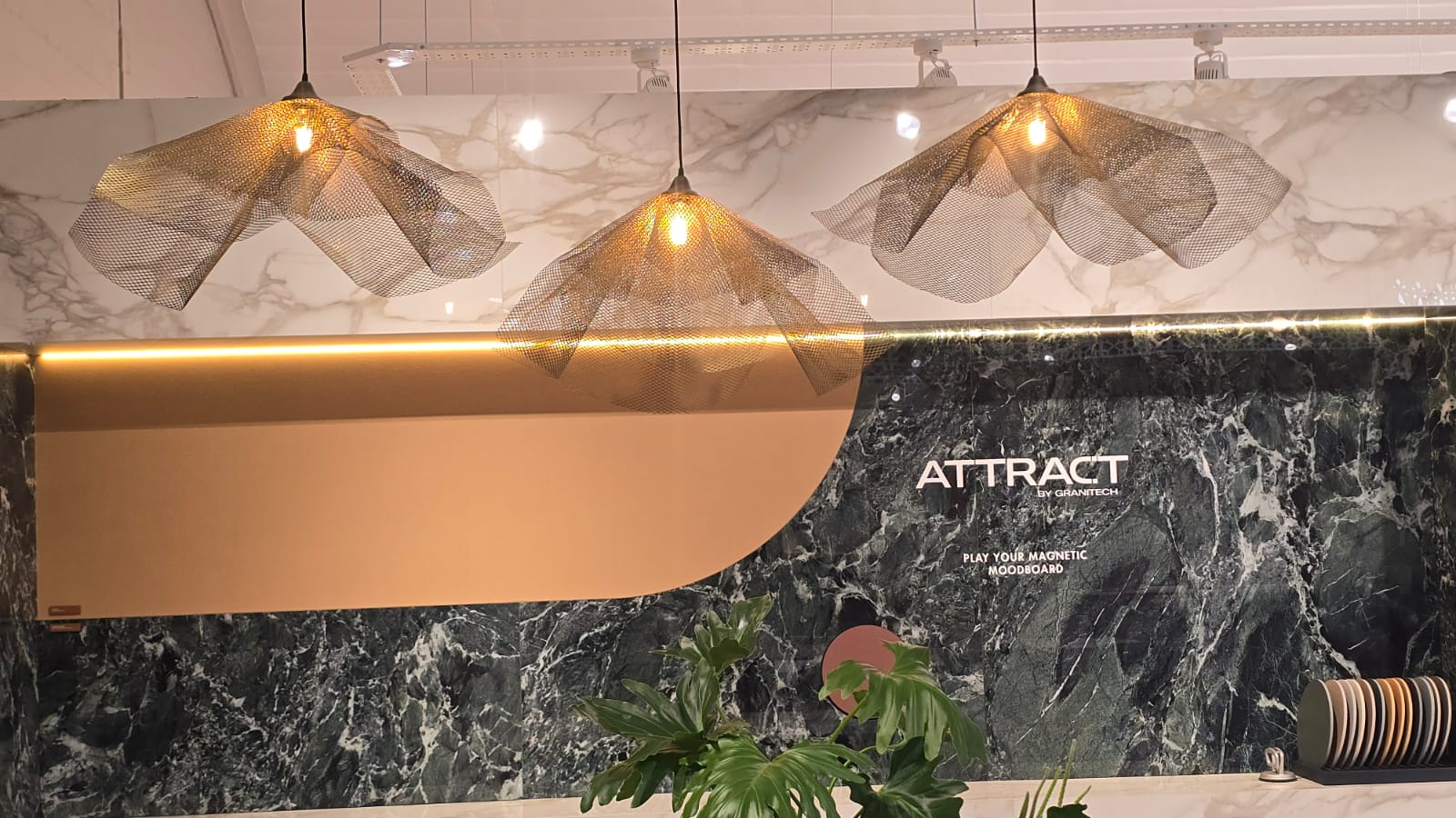 Multiple Gold Bloom Light fittings in a back drop of wall tiles