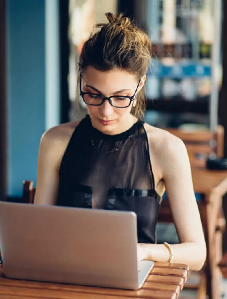 Woman working on laptop wearing glasses