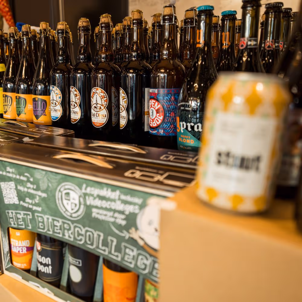 Rekken gevuld met verschillende soorten ambachtelijke bierflessen en blikjes als kerstpakket geschenk op de kerstmarkt