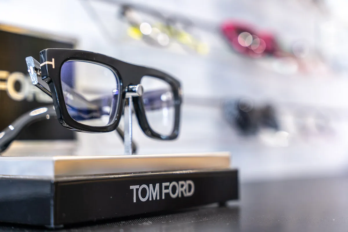 Tom Ford black square designer glasses frames on display stand at an independent opticians