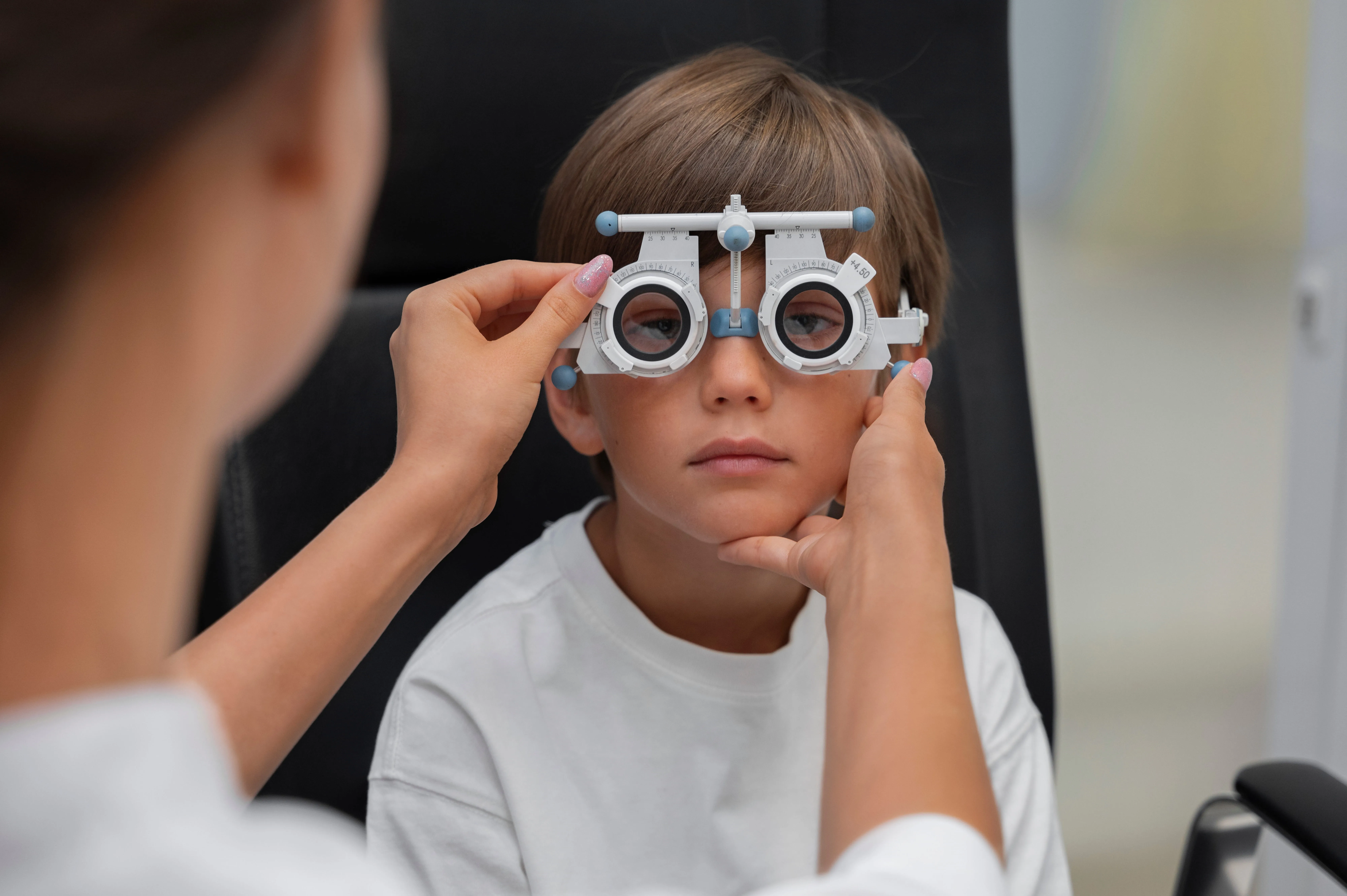 Child wearing optical phoropter during vision eye examination test