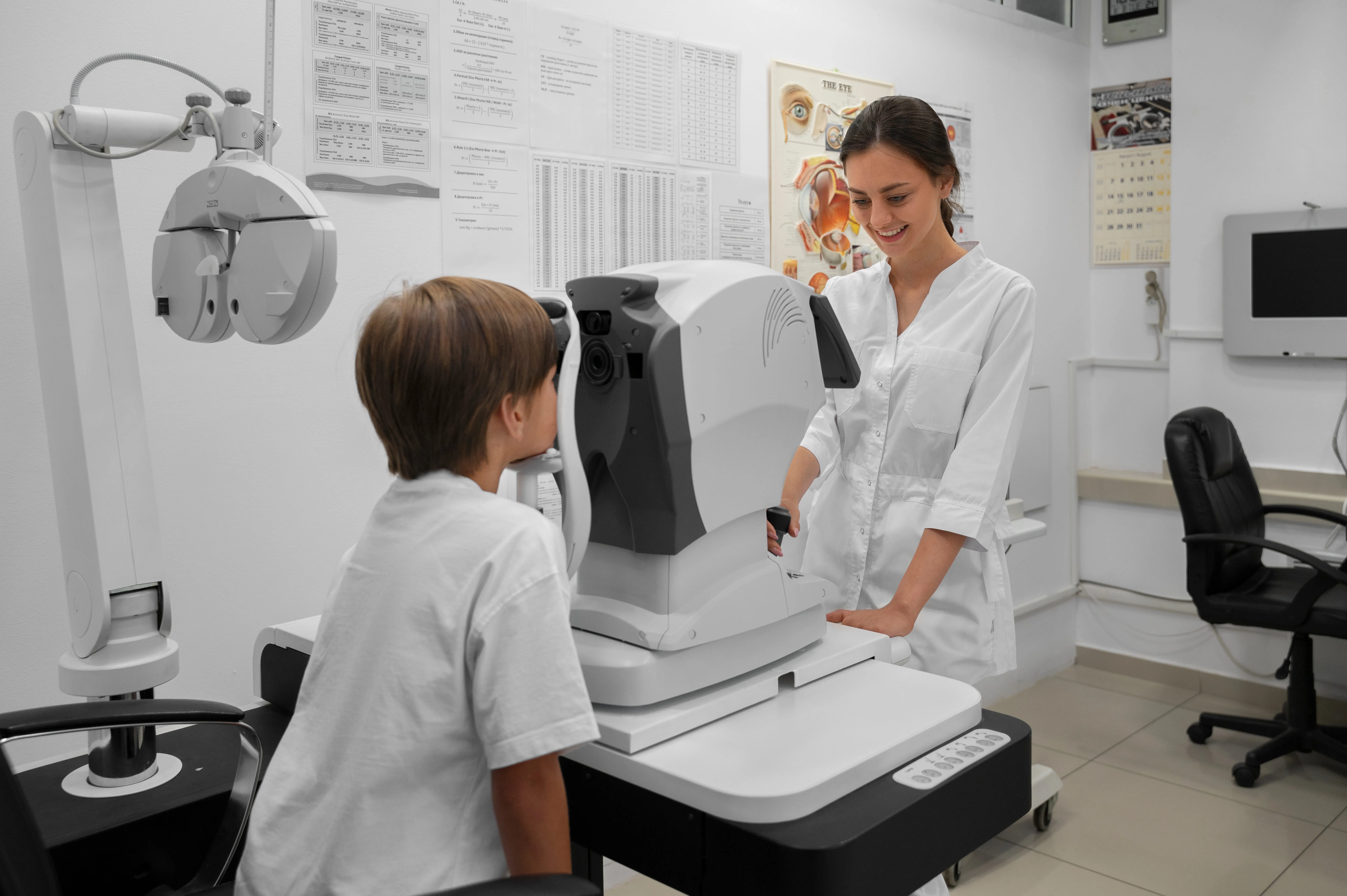 Optometrist examines child's eye using advanced autorefractor equipment in modern clinic.