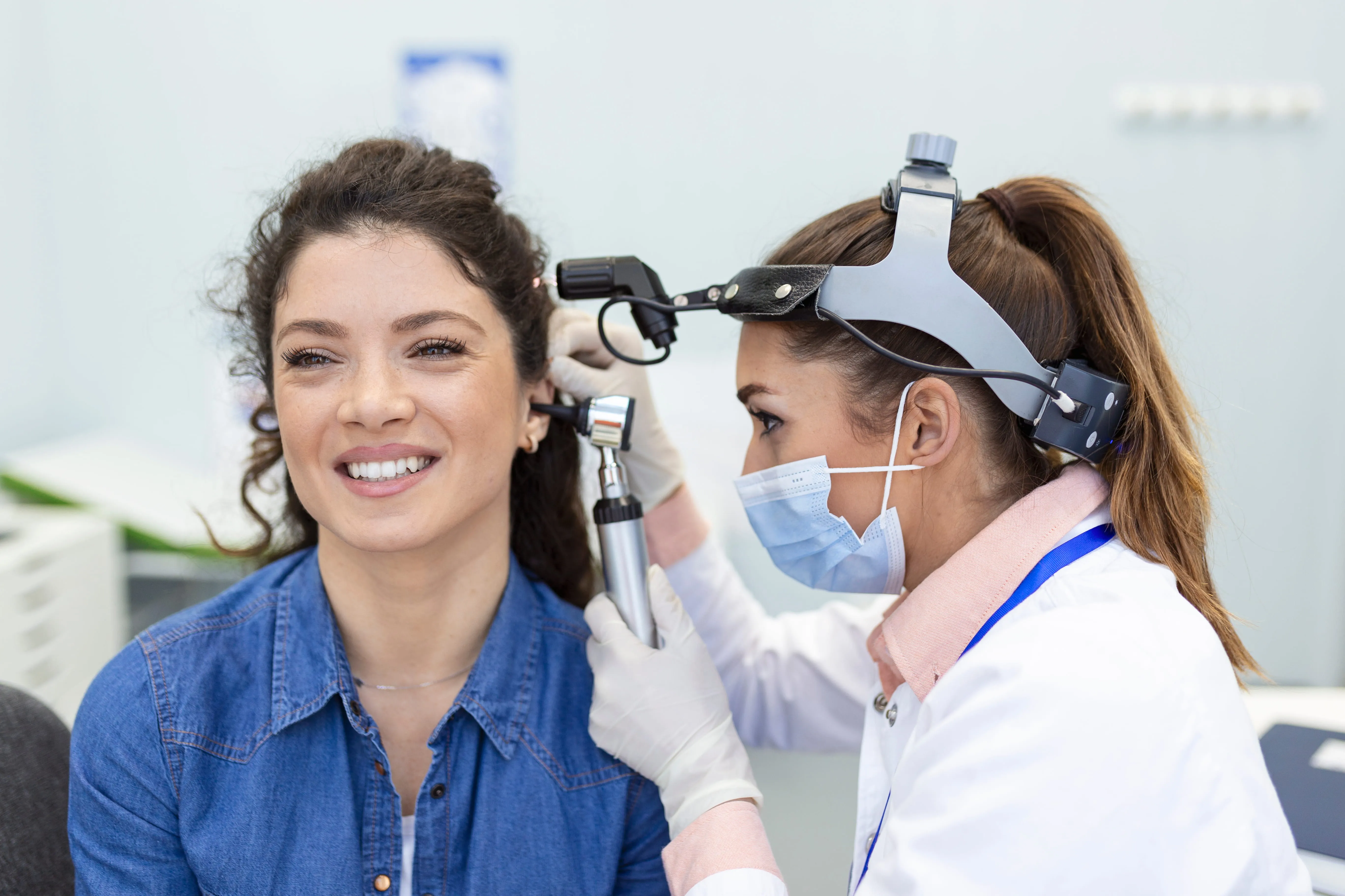 Dentist examining smiling patient's teeth with intraoral camera in dental clinic