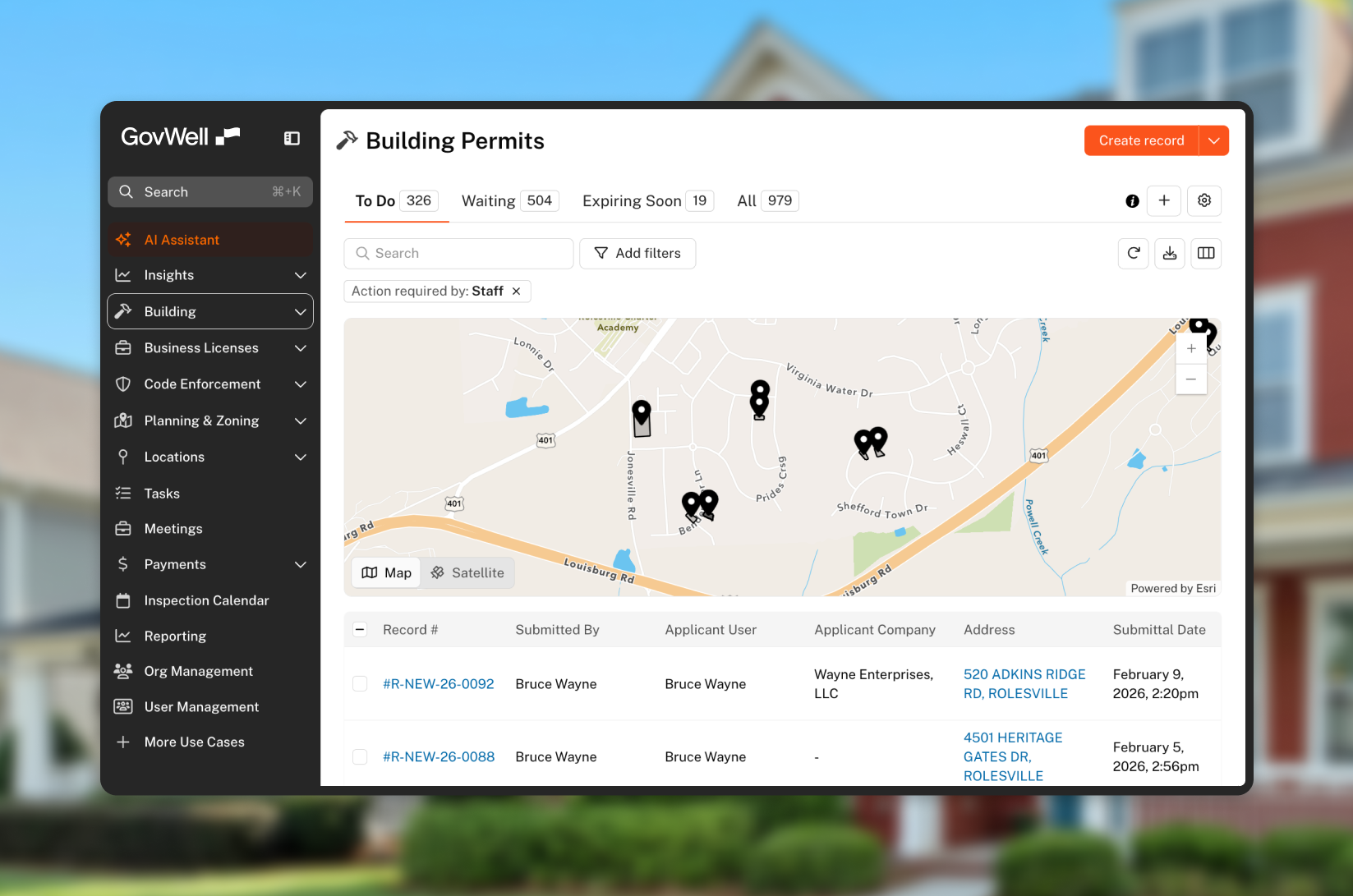 GovWell dashboard showing building permits with a map highlighting locations and a table listing permit records submitted by Bruce Wayne.