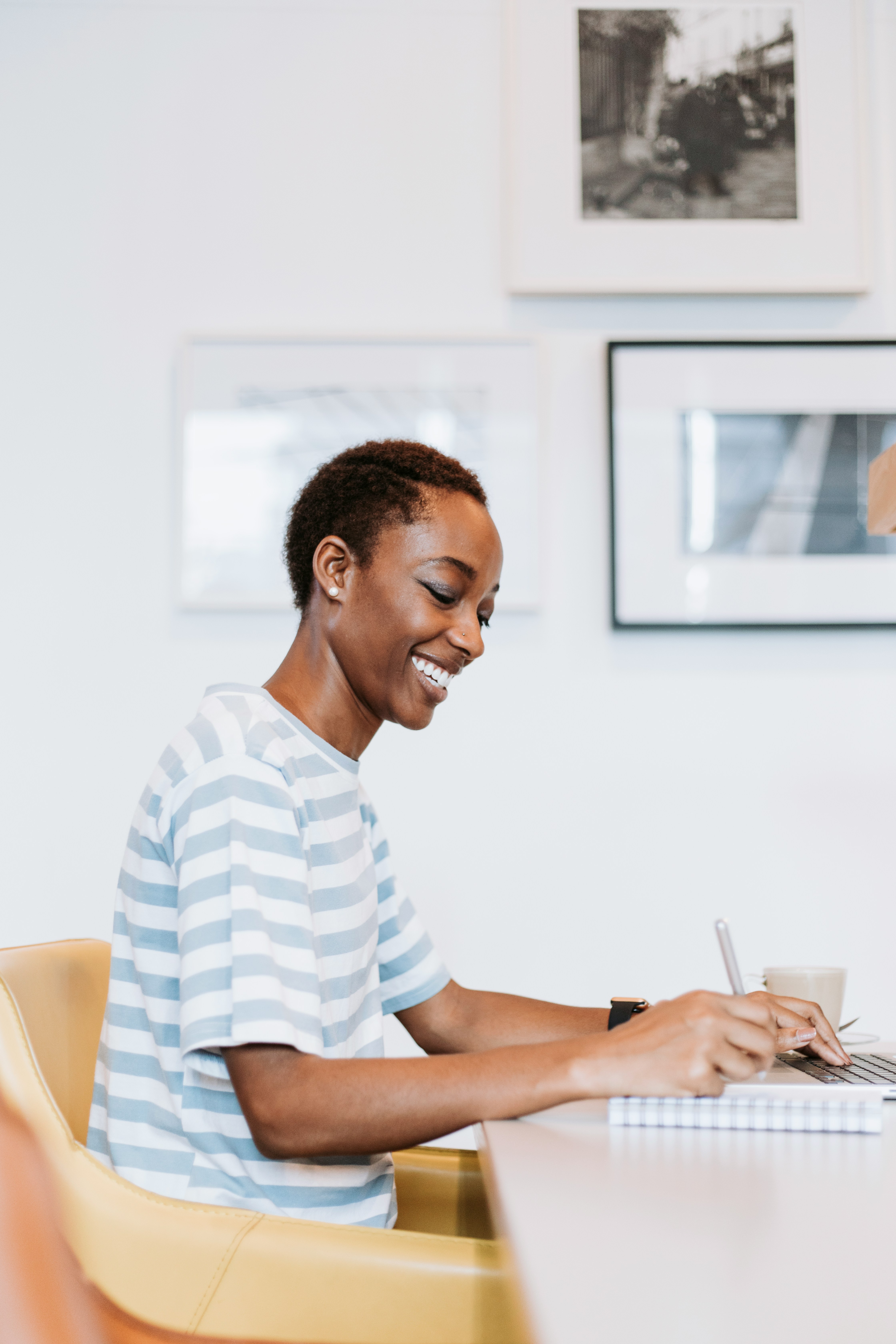 Femme souriante en train d'écrire à son bureau