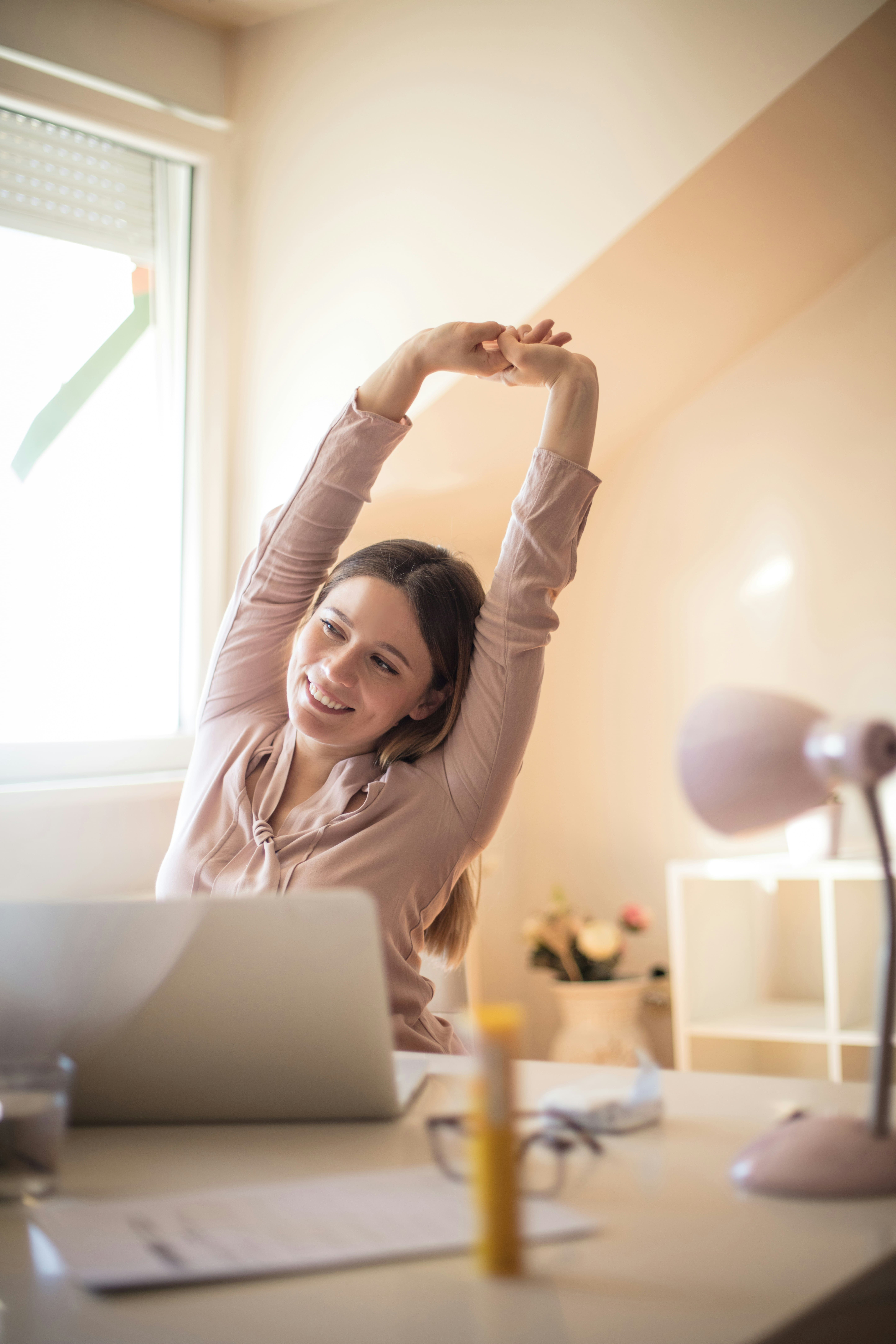 Femme en train de s'étirer à son bureau