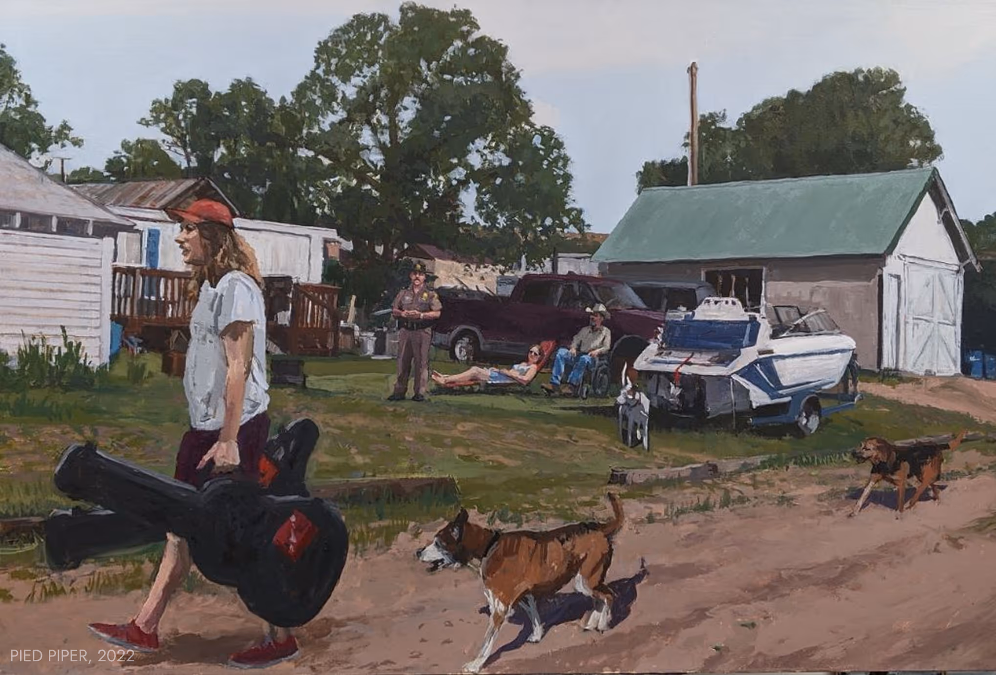 Person in red cap carrying guitar cases on dirt path with dogs, people, truck, boat, and buildings behind.