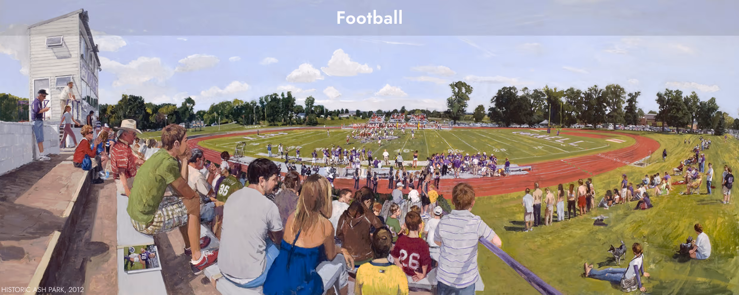 Panoramic view of spectators watching a daytime football game on a grassy field surrounded by a running track.
