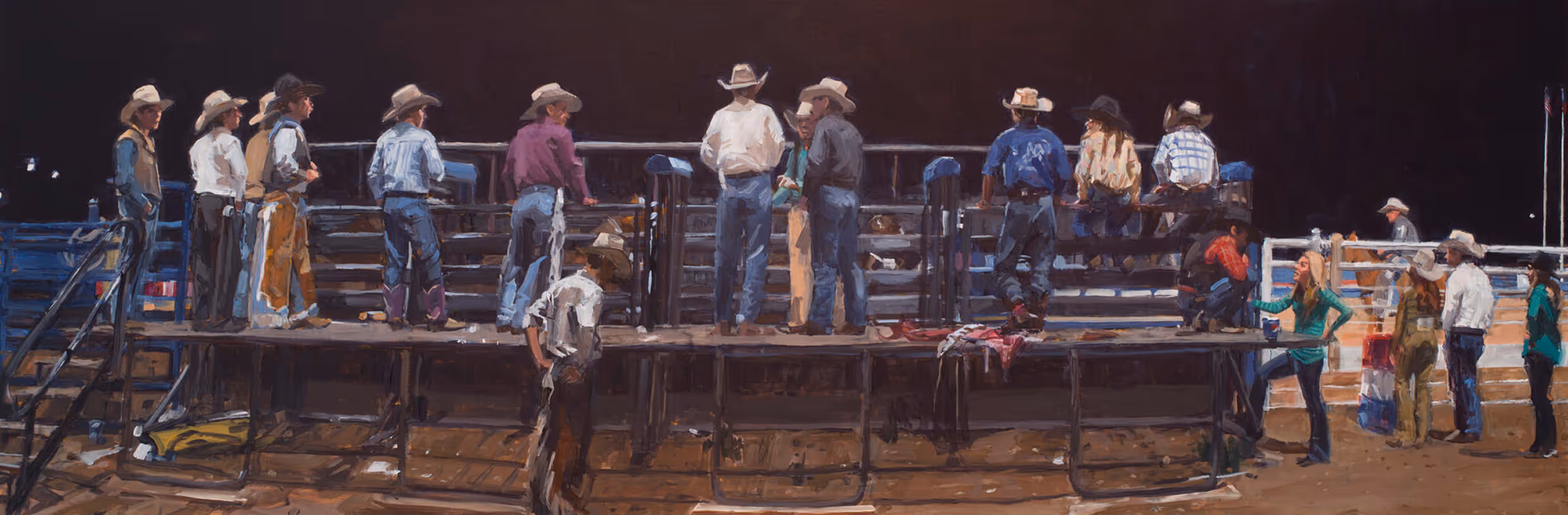 Cowboys and a few women in western hats and attire gathered around a rodeo arena at night.
