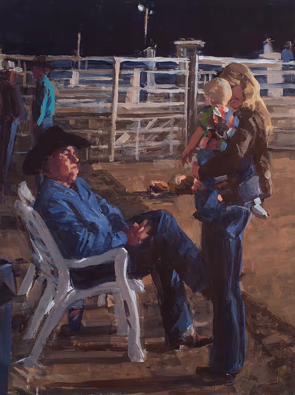 Man in cowboy hat sitting on plastic chair and woman holding child near a fenced area at night.