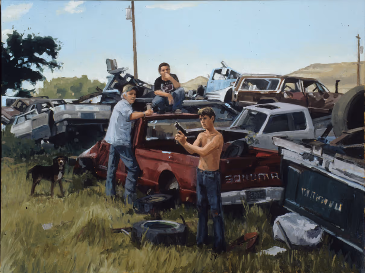 Three boys in a junkyard with old cars and a dog, one shirtless boy holding a gun-shaped object.