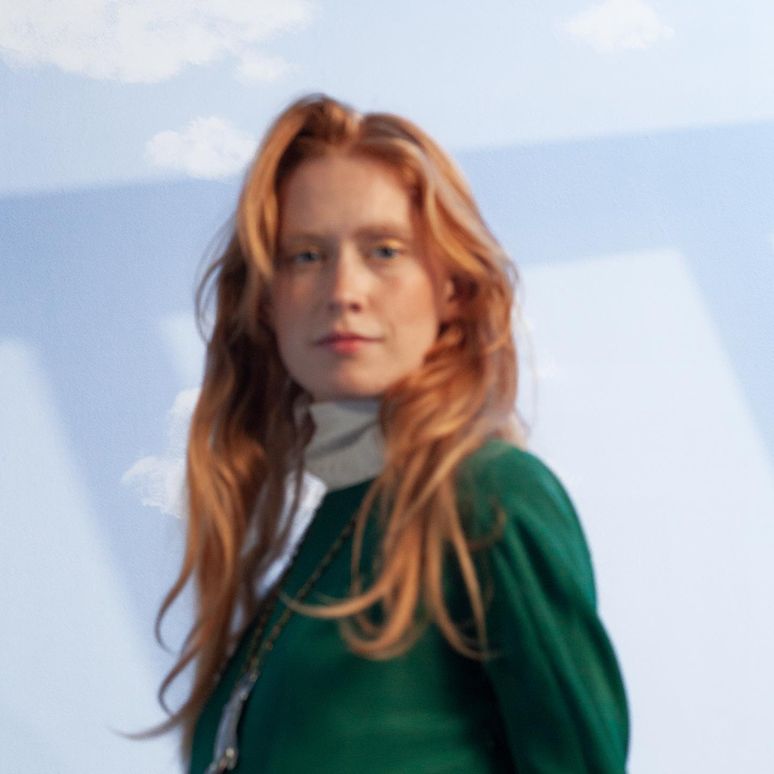 Back view of a long-haired model in a studded burgundy waistcoat