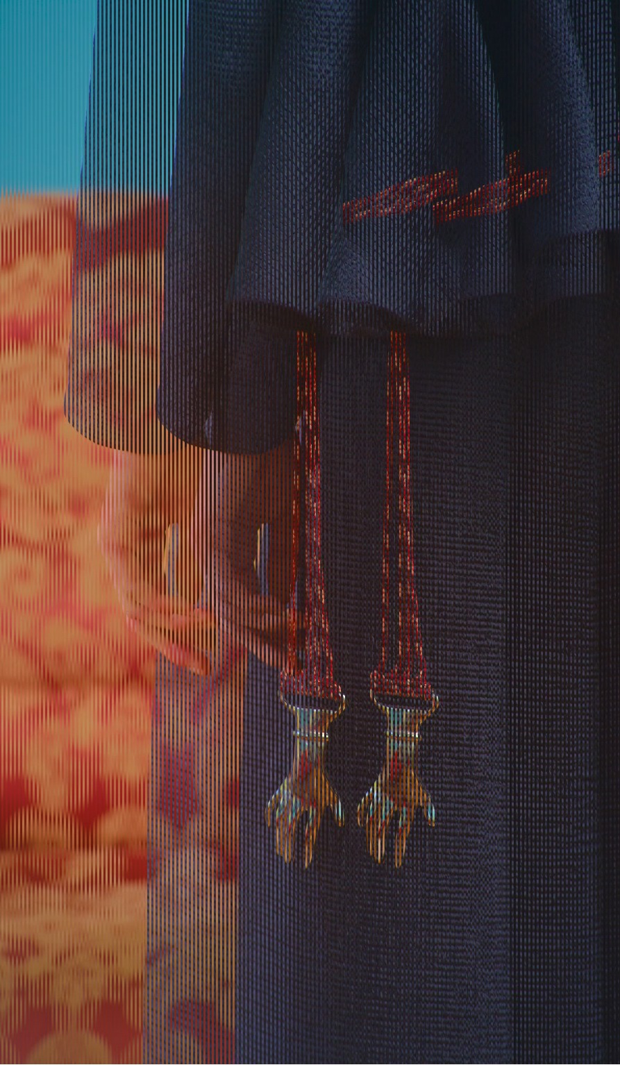 Braided cords with gold hand-shaped clasps on pleated fabric