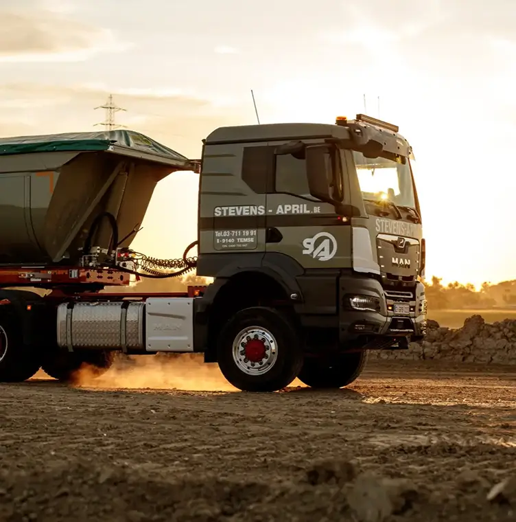Vrachtwagen Stevens - April op modderige bouwplaats bij zonsondergang.