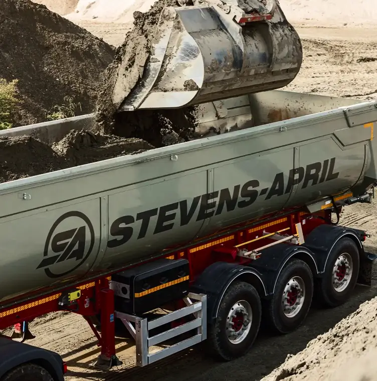 Grond wordt geladen in een Stevens-April kiepwagens tijdens een bouwproject.