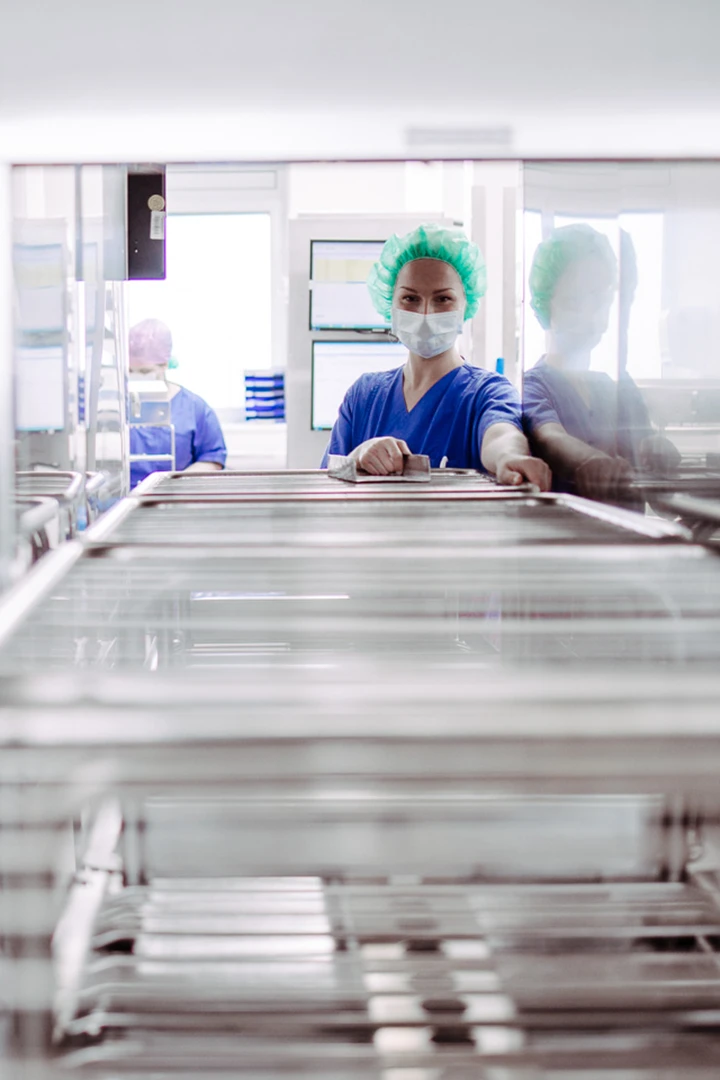 Mitarbeiterin im OP-Bereich bei Vorbereitung medizinischer Instrumente