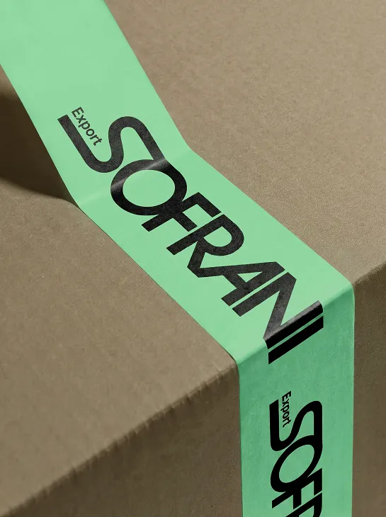 Brown cardboard box sealed with green tape printed with black text 'Export SOFRANI'.