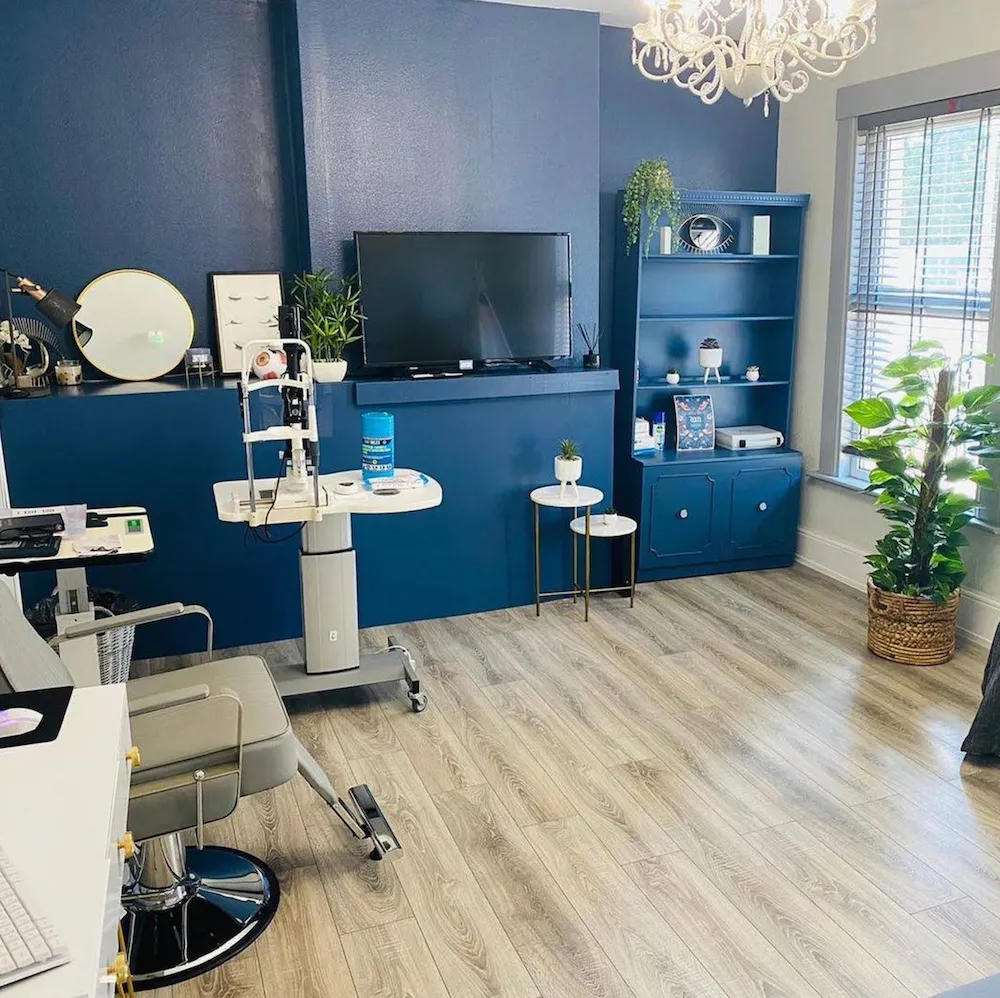 Modern beauty salon interior with blue accent walls, styling station, and comfortable seating area