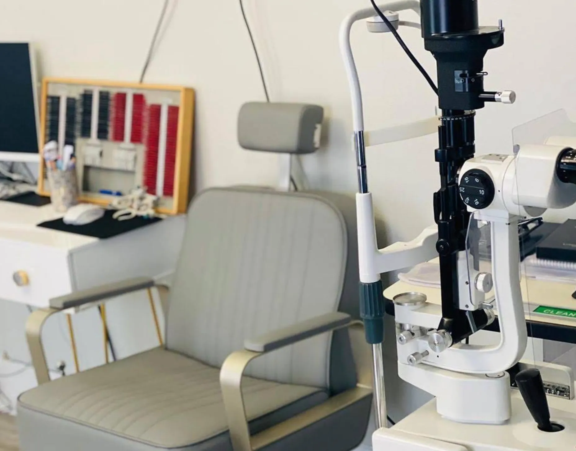 Optometry clinic exam room with slit lamp and patient chair visible.