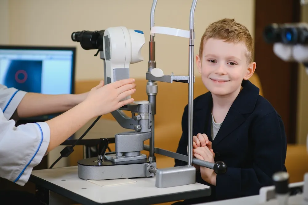 Young boy undergoing eye examination with optometric equipment in clinical setting