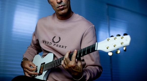 Fotografia de alguém a tocar a guitarra.