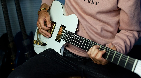 Fotografia de alguém a tocar a guitarra.