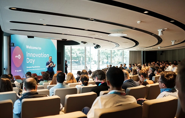 Photograph of a group of people in the auditorium being welcomed to Galp's Innovation Day.