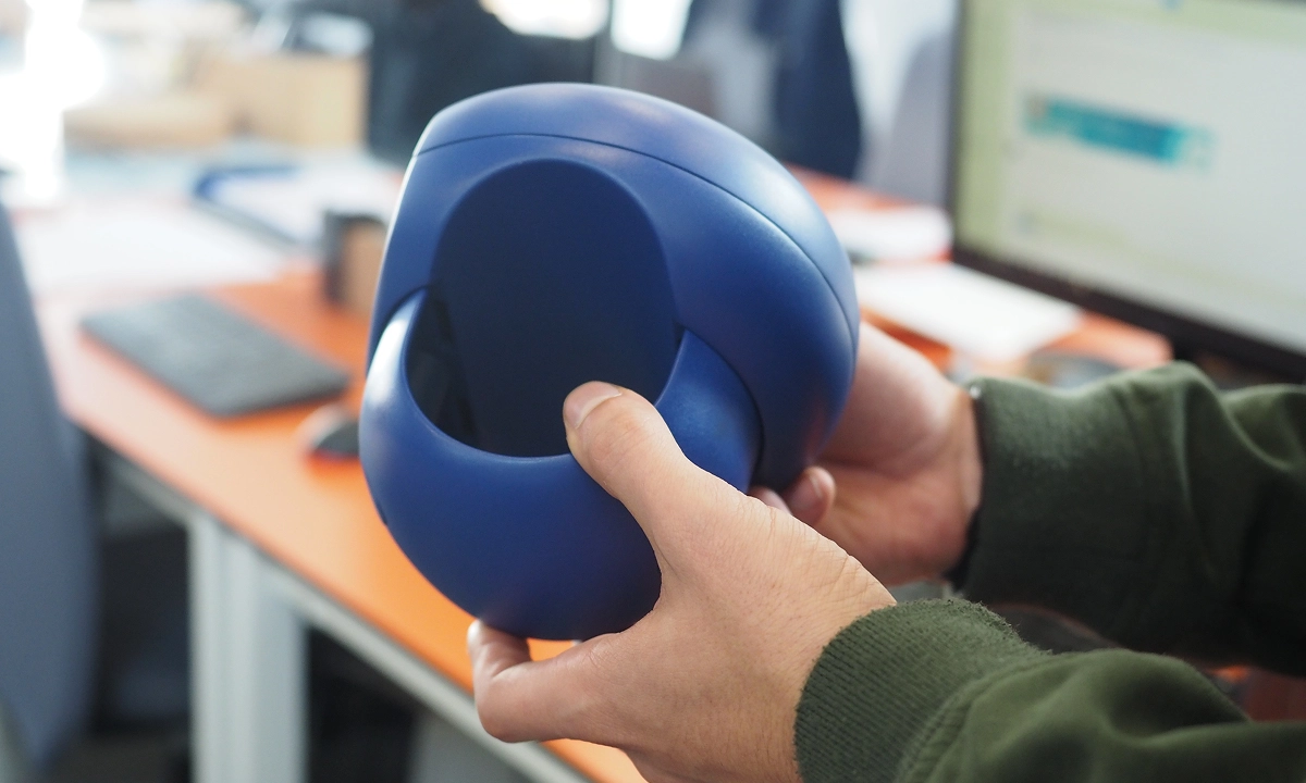 Fotografia de um protótipo do Beacon a ser manuseado.