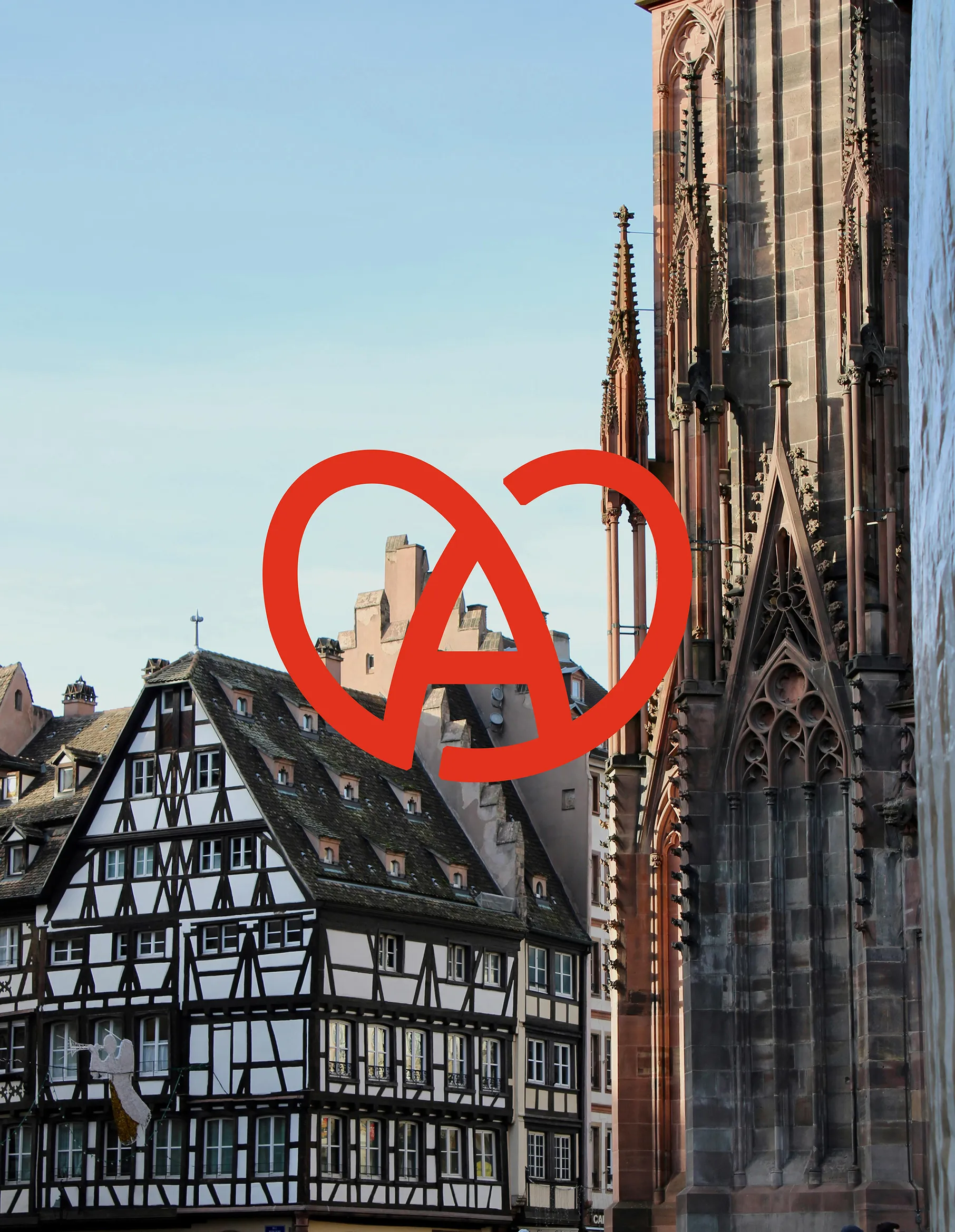 Photo de la cathédrale de Strasbourg avec un beau ciel bleu et une maison alsacienne. Par dessus la photo, il y a le logo de la marque Alsace.