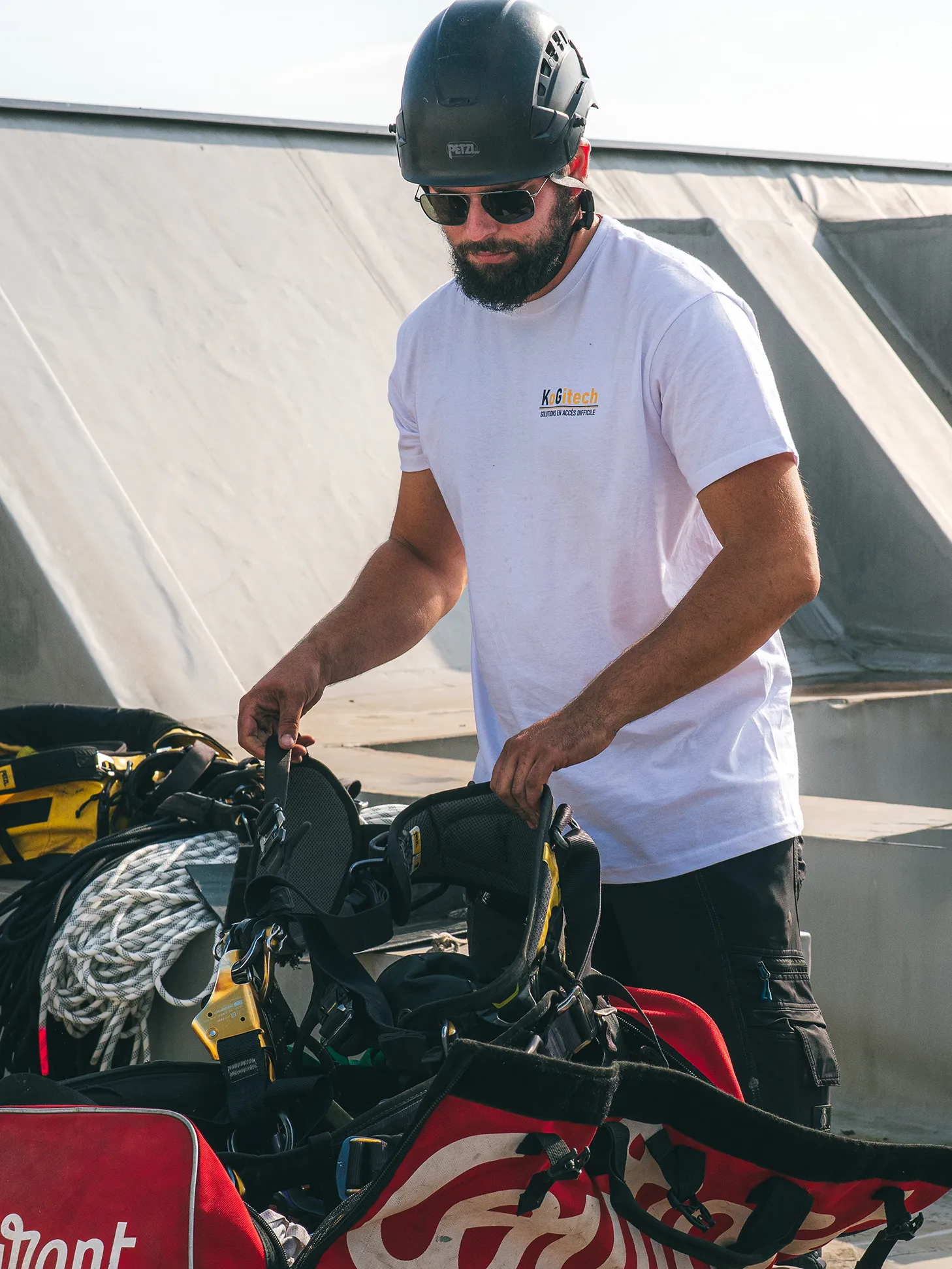Une technicien cordiste qui prépare son matériel pour une mission.