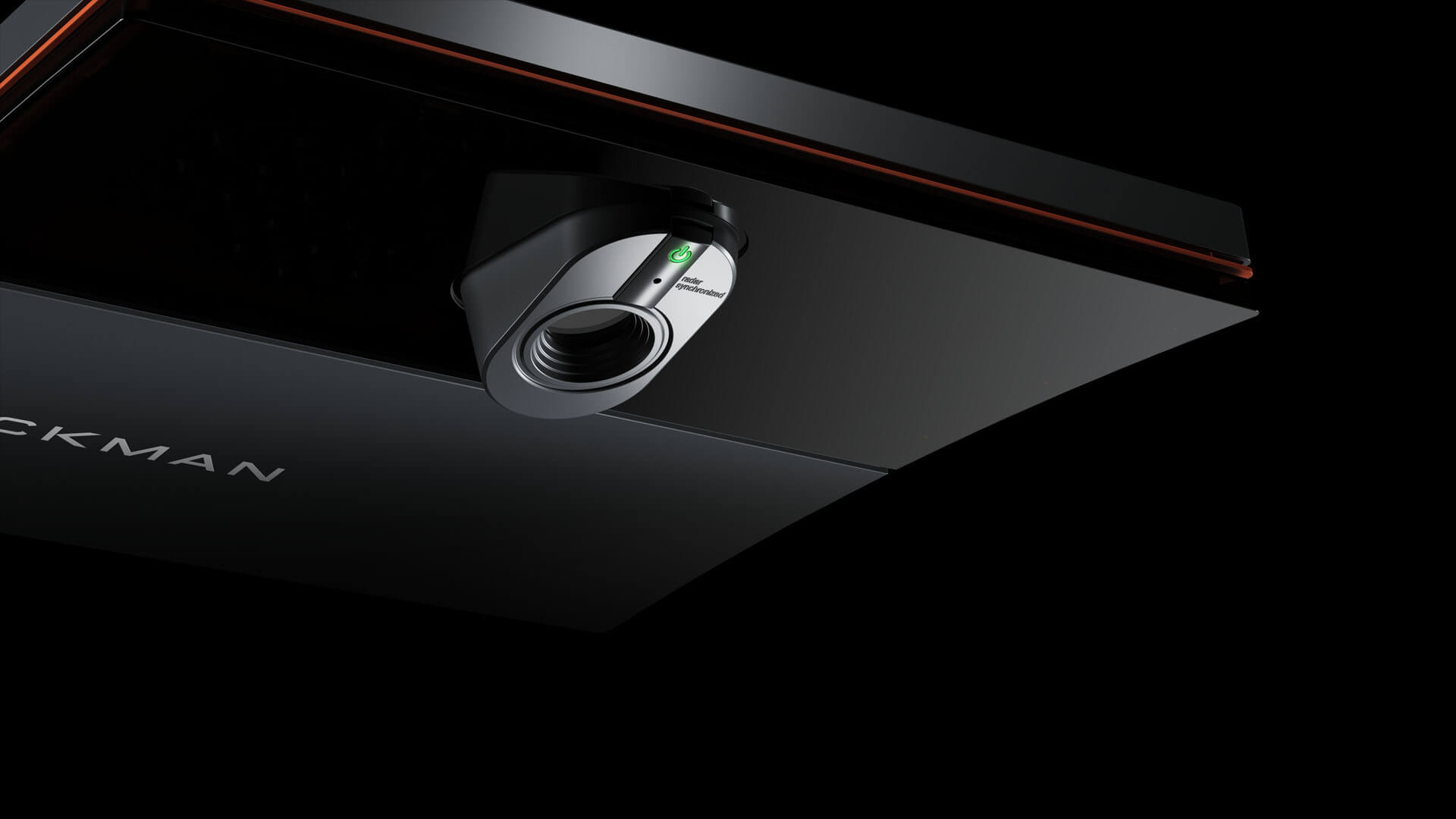 Close-up of a sleek black projector with the green power button illuminated, mounted on a dark surface.