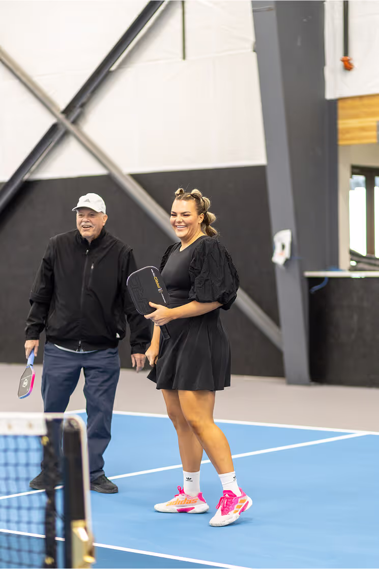 Indoor golf simulator screen displaying golf course, shot metrics, and ball trajectory on artificial turf flooring.