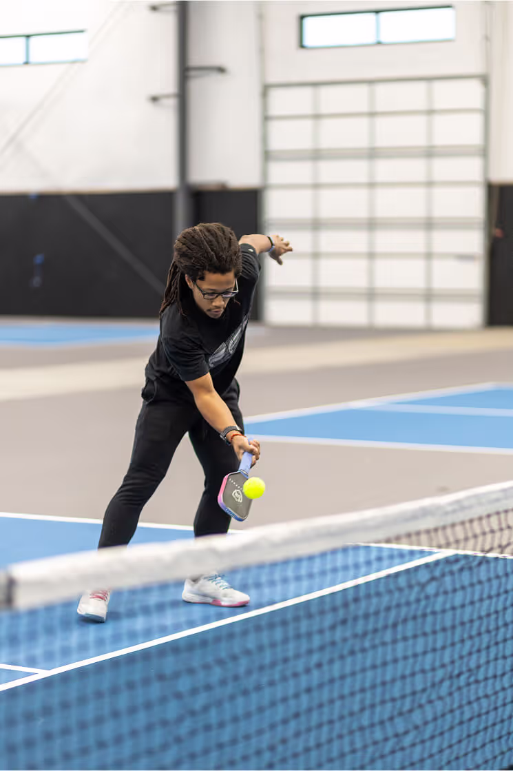 Indoor golf simulator screen displaying golf course, shot metrics, and ball trajectory on artificial turf flooring.