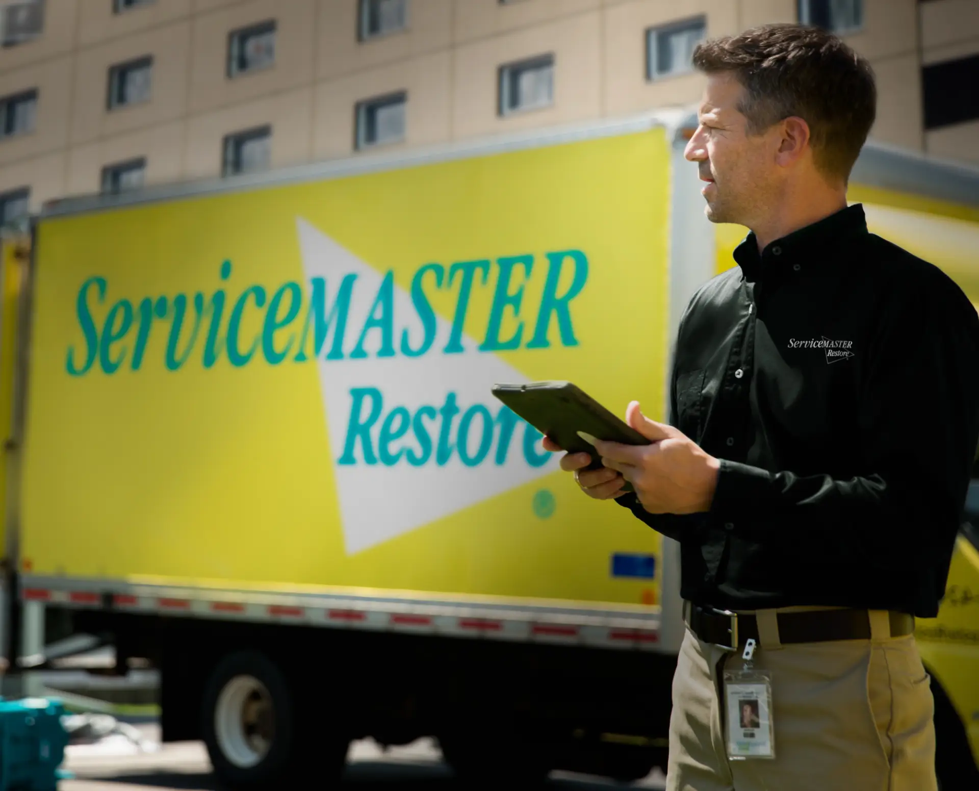 ServiceMaster Restore representative and truck in front of a commercial building