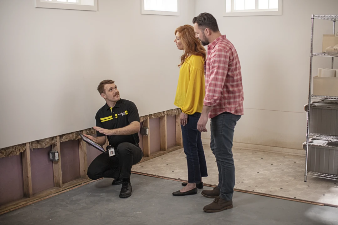 Service technician consulting homeowners about water damage restoration