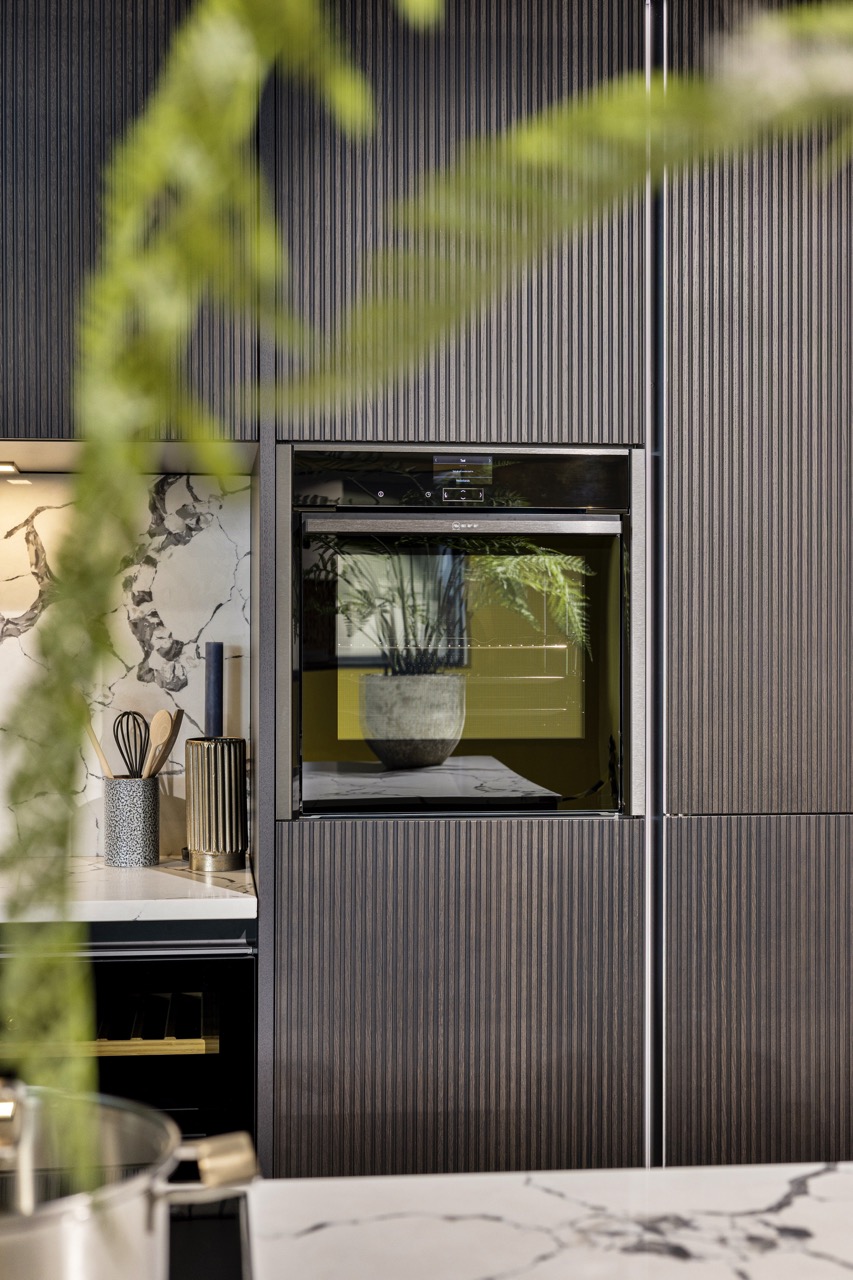 Inbouwoven in donkere ribbelfronten met marmerlook achterwand - Showroom Borculo Marboma