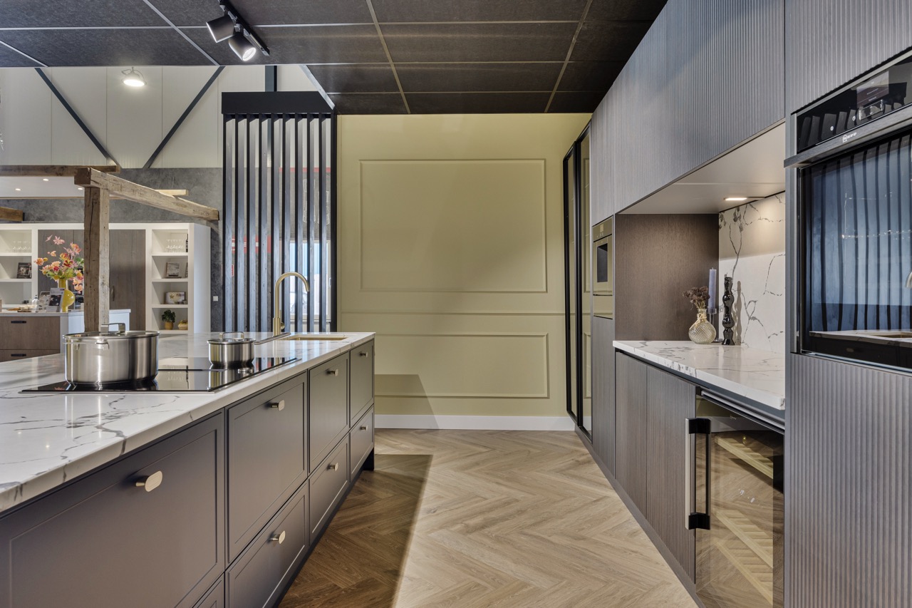 Keuken met kookeiland, hoge kastenwand en visgraat vloer - Showroom Borculo Marboma