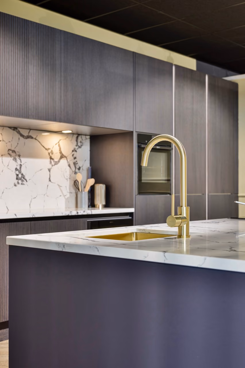 Moderne keuken met gouden kraan, marmerlook werkblad en ribbelfronten - Showroom Borculo Marboma
