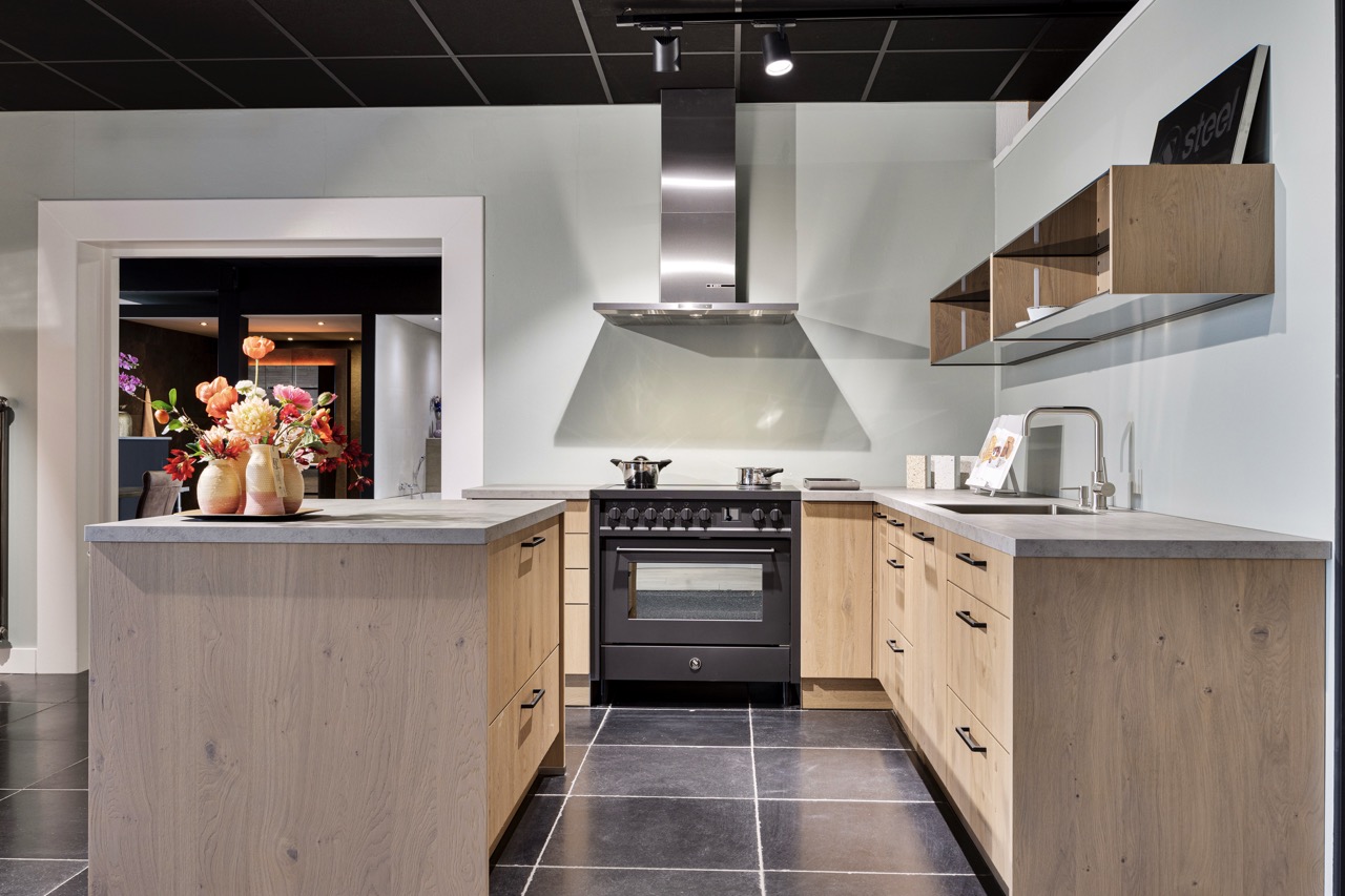 Keuken in houtlook met fornuis, schiereiland en tegelvloer - Showroom Borculo Marboma